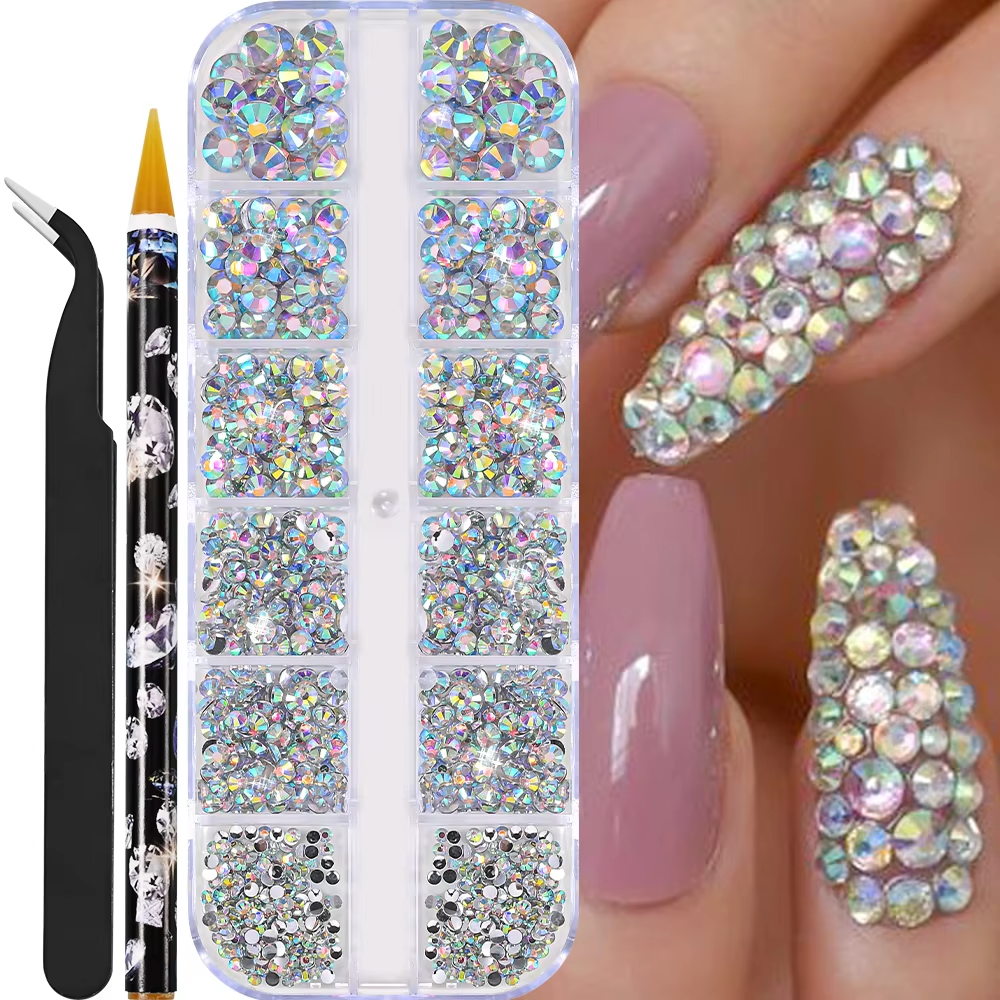 A set of nail art rhinestones organized in a plastic container, with a black tweezer and a pencil-like tool next to it, and a close-up of a hand with decorated nails.