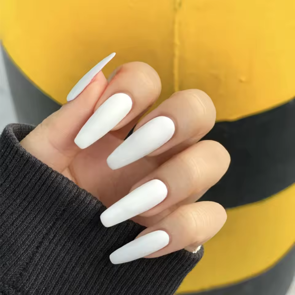 Classic white coffin nails with a glossy finish, showcasing a minimalist and elegant nail art design
