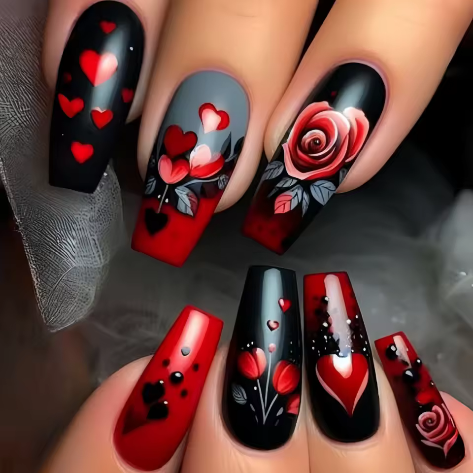 Hyper-realistic gothic stiletto nails with black bases, red hearts, and detailed rose designs, showcasing a romantic and edgy nail art style for 2025.