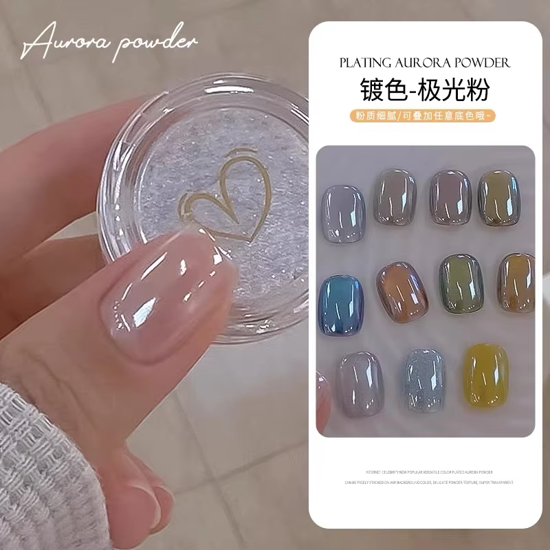 A hand holding a small container of aurora powder with a clear lid and a gold heart design, next to a display of nine different nail samples showing various color effects.